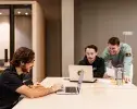 trois étudiants assis travaillant devant leur ordinateur 