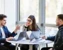 trois étudiants en discussion autour d'une table