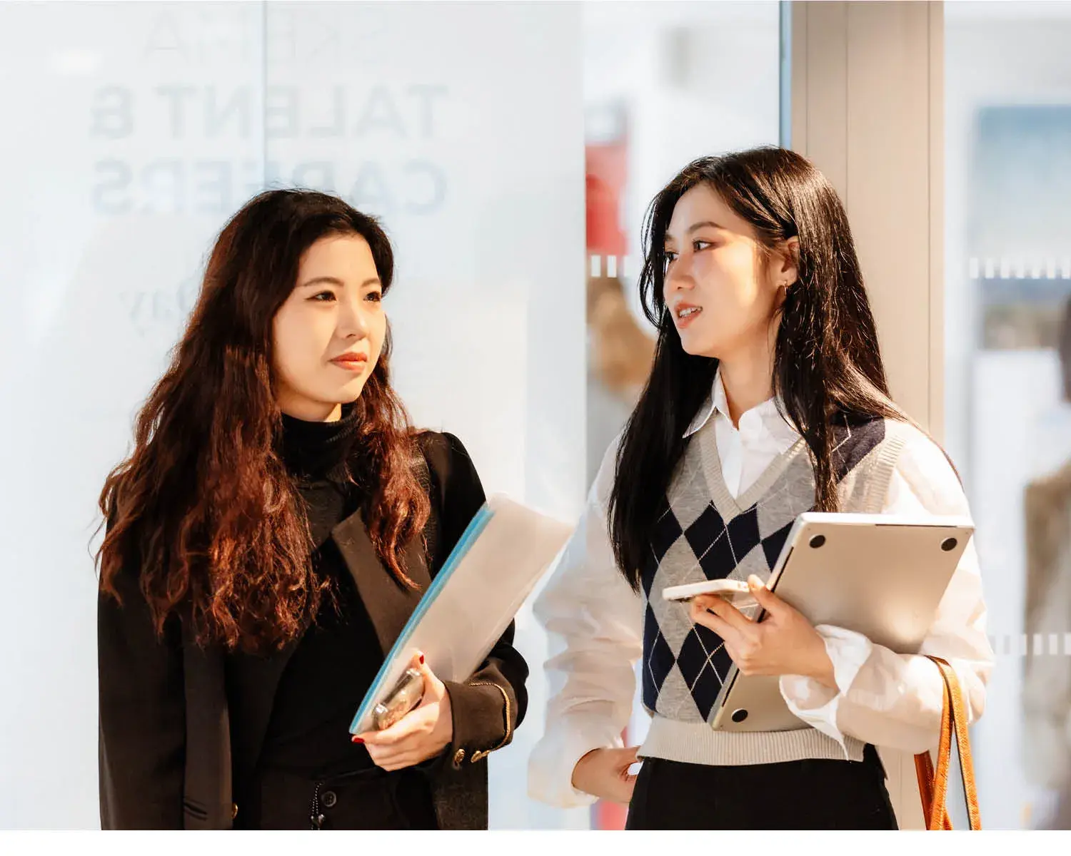 deux étudiantes avec des cahiers dans la main