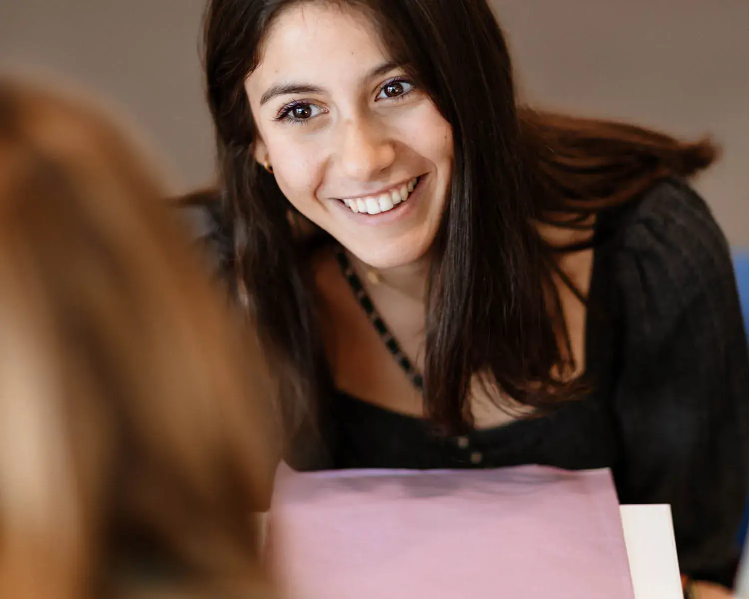 une jeune fille souris à la personne devant elle