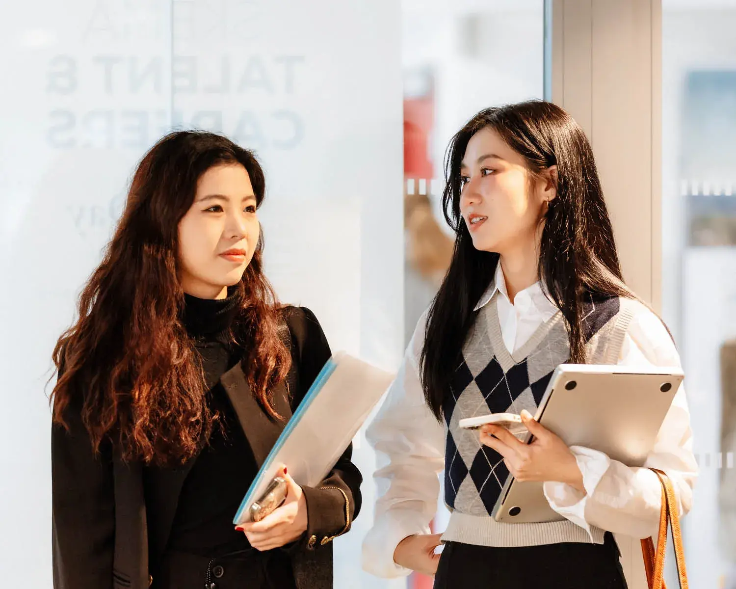 deux étudiantes avec des cahiers dans la main