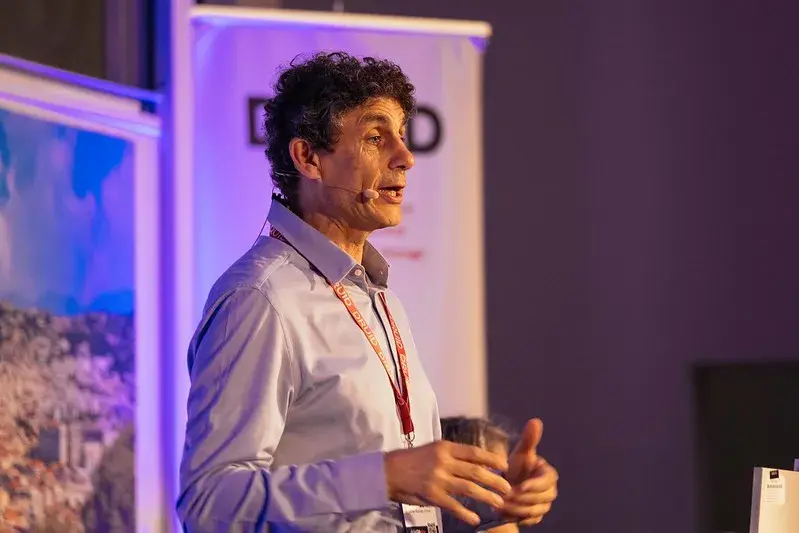 un homme debout faisant une présentation avec un micro accroché à l'oreille