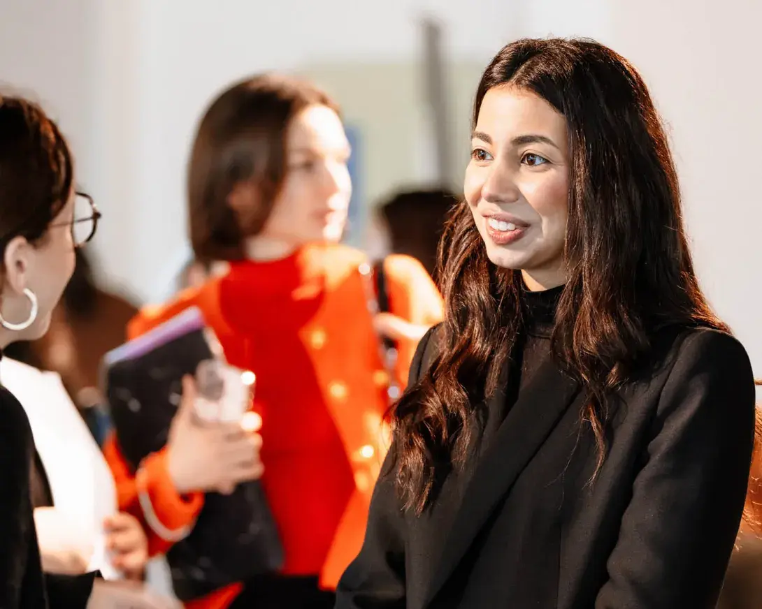 une femme sourit à quelqu'un sur un forum étudiant