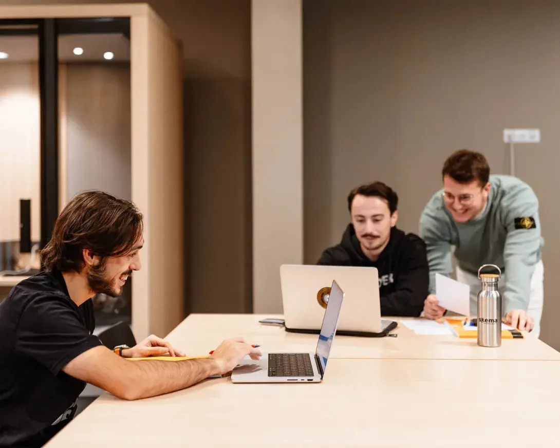 un groupe d'étudiant qui travaillent sur leur ordinateur autour d'une table