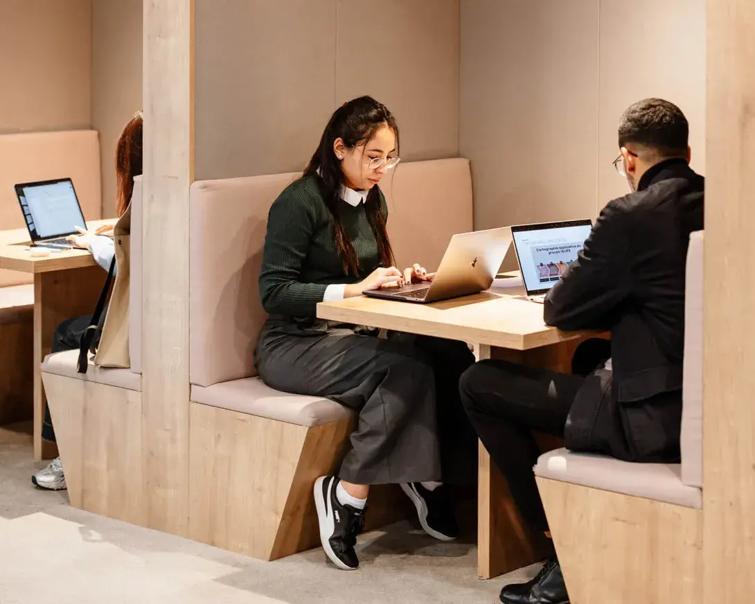 des étudiants qui assis devant leur ordinateur dans un espace de travail