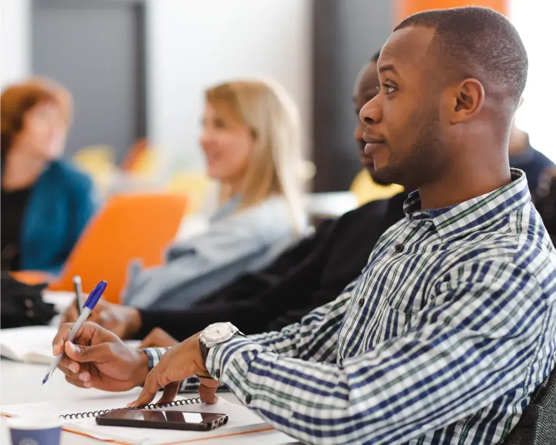 des élèves qui écoutent et prennent des notes