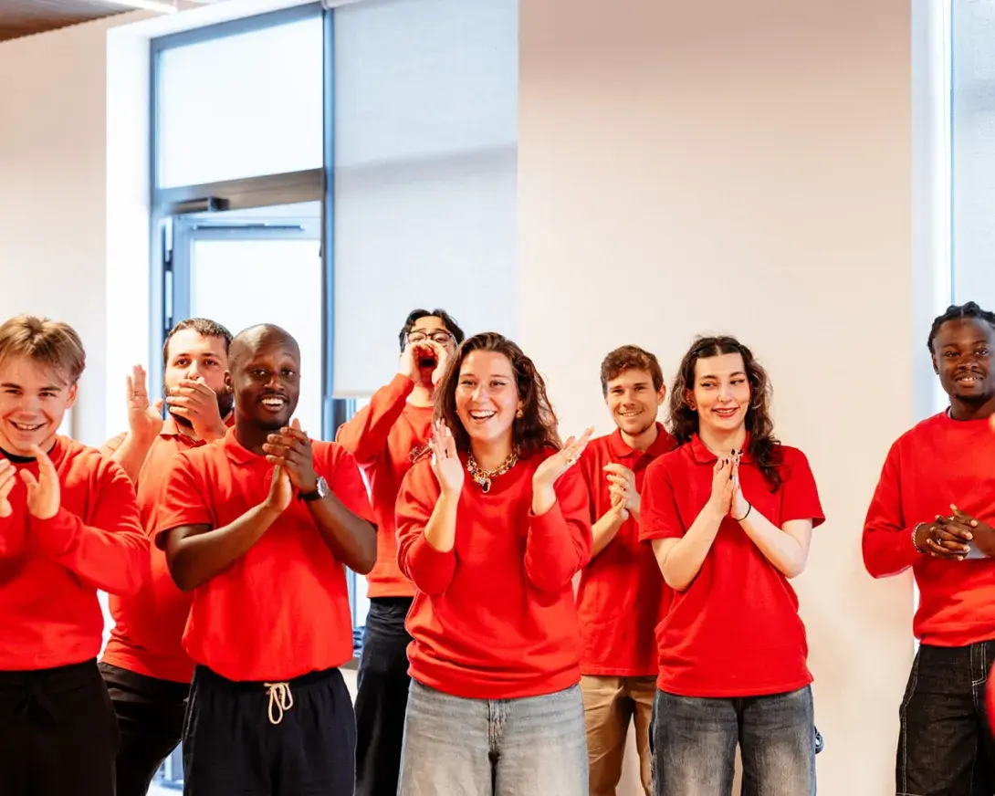 Etudiants souriants qui applaudissent, tous habillés en rouge SKEMA